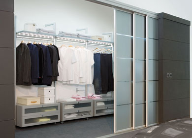 ein begehbarer Kleiderschrank mit Glasschiebetüren