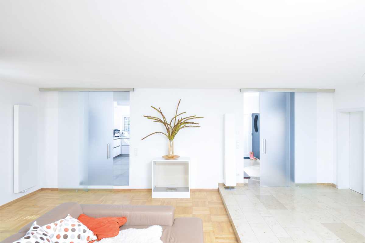 ein heller großer Raum mit 2 Glasschiebetüren