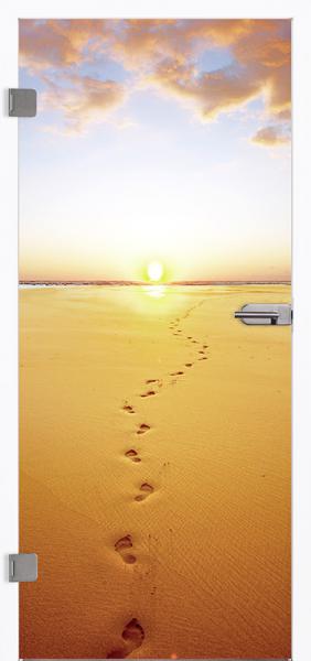 Eine Ganzglastür mit dem Bild eines langen breiten Strandes und Fußabdrücken im Sand beim Sonnenuntergang